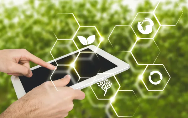 a person in a farm holding a digital tablet, with virtual icons of farming.